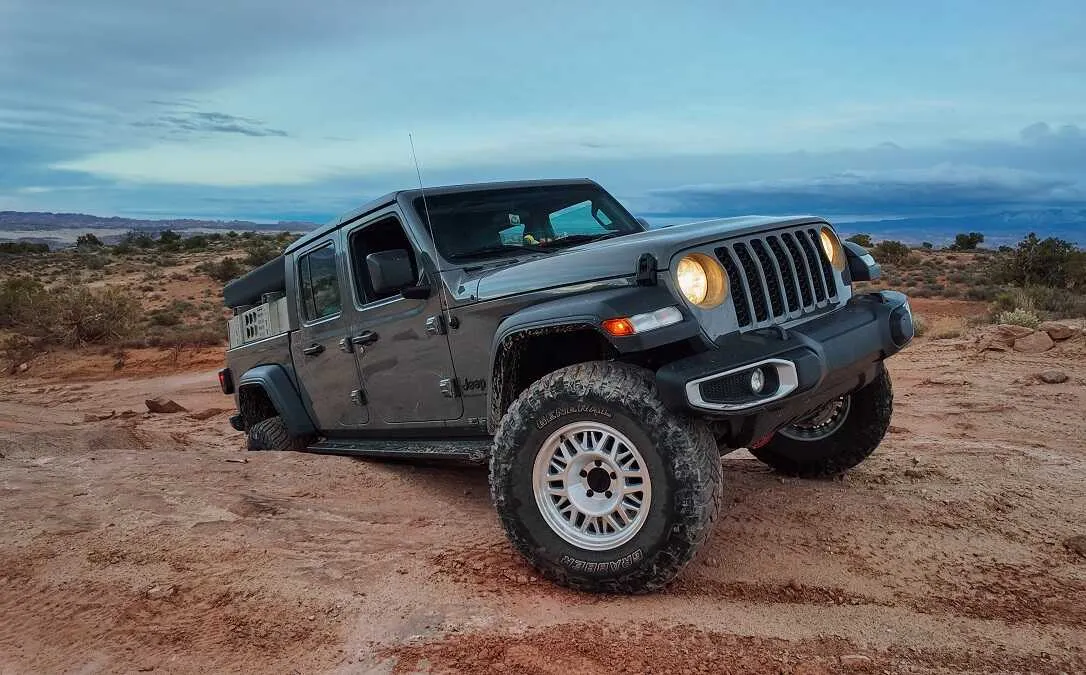 Gladiator with ASFIR rock sliders on a red dirt trail