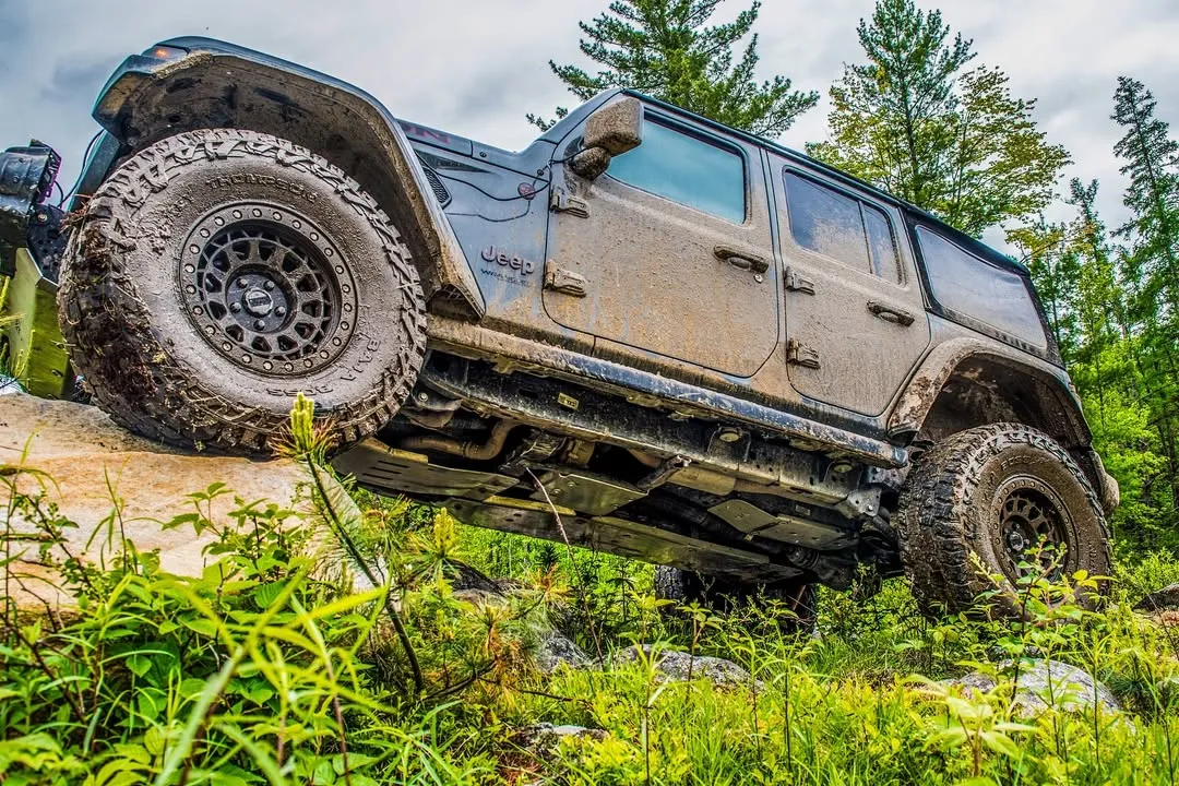 Wrangler Unlimited climbing a ledge in the forest